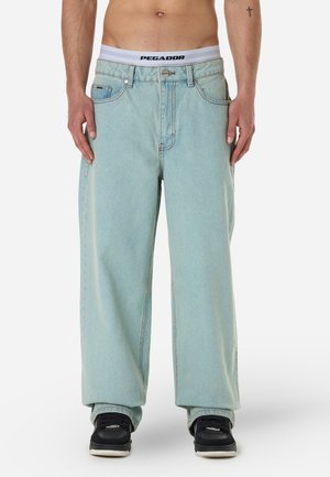 Lyseblå, overdimensjonerte denimjeans med rett ben og fem lommer. Har knapp og glidelås foran.