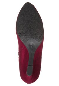 Chaussure en daim bordeaux avec un bout pointu et une semelle en caoutchouc noire texturée. Une fermeture éclair latérale ajoute une touche fonctionnelle à la conception.