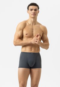 Dark gray boxer briefs with a textured pattern, elastic waistband, and a fitted design, displayed by a muscular male model against a plain background.