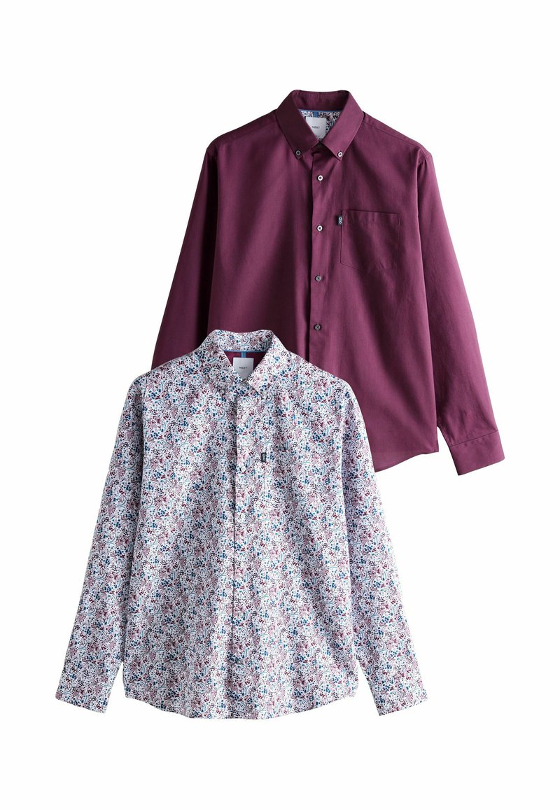 Dve košele s dlhým rukávom: jedna jednofarebná bordová s vreckom, druhá s drobným multicolor kvetinovým vzorom na svetlom pozadí.