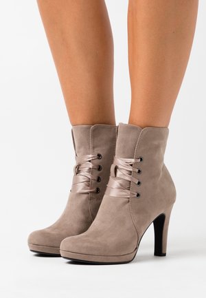 Botines de ante topo con punta afilada, cordones de satén pasados por ojales de metal y un tacón de aguja de 5 pulgadas. Textura suave.