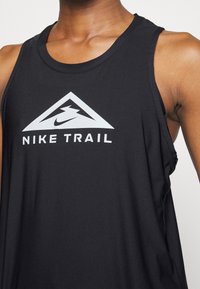 Débardeur de sport noir avec logo blanc Nike Trail représentant une montagne et un éclair sur la poitrine.