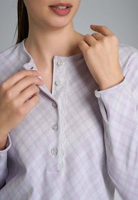 Blusa a quadri lilla con una patta di chiusura con bottoni, caratterizzata da una rifinitura in pizzo e bottoni argentati. Tessuto morbido con una vestibilità comoda, maniche con polsini.