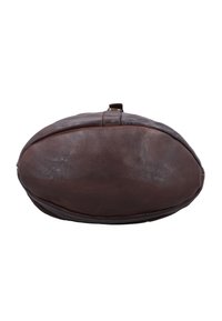 Brown leather oval-shaped bag viewed from the bottom with visible seams and zipper pull tab on a white background.