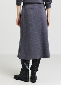 Grauer knielanger Rock mit glatter Textur, ausgestelltem Design und angepasstem Taillenbund, kombiniert mit schwarzen kniehohen Stiefeln.