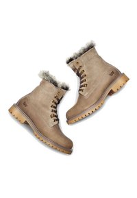 Beige Wildleder-Stiefeletten mit Kunstfellfutter, Metallösen, braunen Schnürsenkeln und robusten Gummisohlen mit einem markanten Profil.