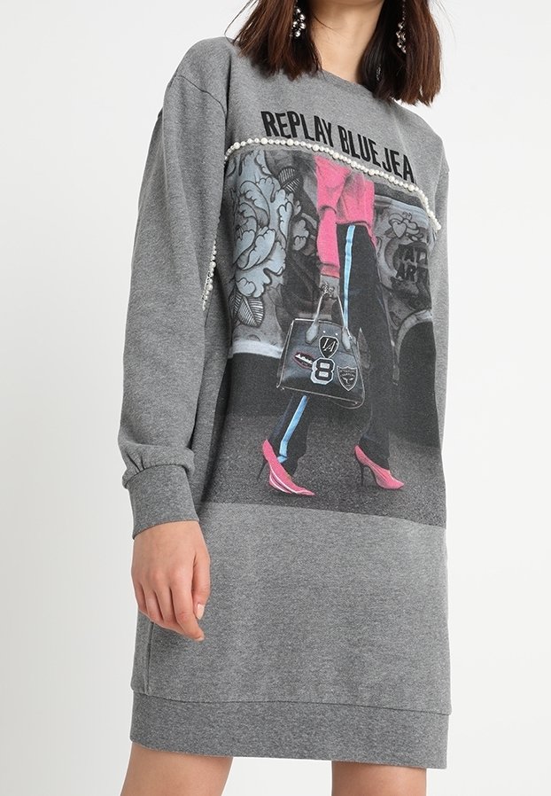 Vestido de sudadera gris con una imagen impresa de una persona en zapatos de tacón rosa y un bolso elegante, acentuado con detalles de perlas en el escote.
