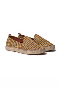 Espadrilles trenzadas en rayas amarillas, naranjas y azules con detalles de cuero marrón y suela de yute. Diseño tipo slip-on, punta redondeada.