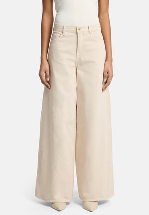 Pantaloni a gamba larga in cotone beige chiaro. Vita alta, chiusura con bottone classico e due tasche frontali. Texture liscia con cuciture visibili.