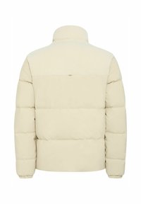 Chaqueta de plumas crema con cuello acanalado, textura acolchada, dobladillo ajustado y sin herrajes visibles. Presenta un color sólido y un acabado liso.