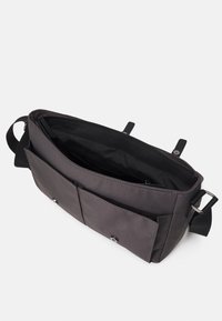 Borsa a tracolla nera realizzata in tessuto durevole, con apertura superiore, tasca interna, due tasche frontali e tracolla.