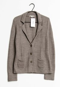 Blazer gris texturizado con solapa, tres botones de madera y dos bolsillos frontales. Cuelga de un gancho negro con una etiqueta de precio adjunta.