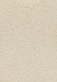 Pull en tricot beige avec un col rond, une texture douce et un motif subtil de petites taches pour plus de détails.