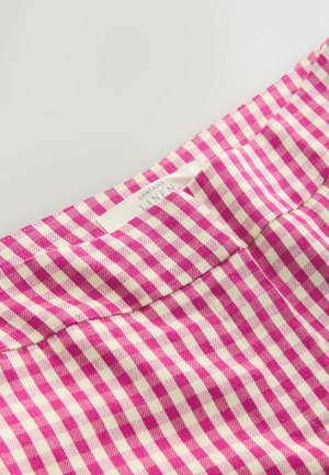 Linnedstof med et pink og cremefarvet ternet mønster. Etiket er synlig og angiver materialets indhold. Teksturen ser glat og vævet ud.