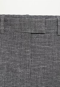Szary i czarny materiał w wzór houndstooth o gładkiej fakturze. Posiada elastyczny pas i detale tylnej kieszeni. Geometriczny wzór na całej powierzchni.