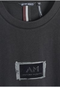 Camiseta de algodón negra con cuello redondo, corte regular y un estampado rectangular en gris con "ANTONY MORATO" y acentos del logo "AM".