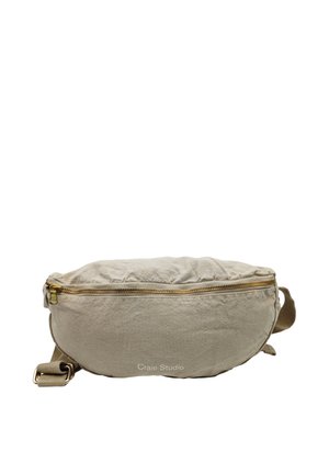 Sac banane en tissu beige avec fermeture éclair dorée et sangle réglable, forme ovale, logo "Craie Studio" embossé sur le devant.