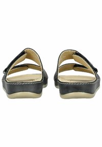 Sandales en cuir noir avec arrière ouvert, plusieurs sangles, doublure intérieure beige et couture contrastante le long du bord de la semelle.