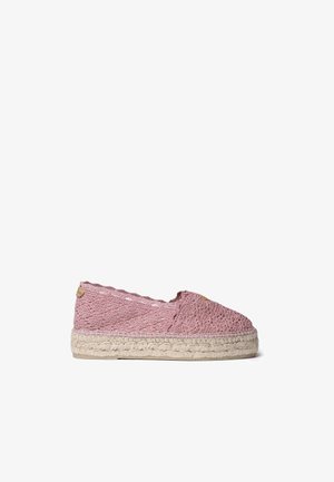 Alpargata rosa de crochet tipo slip-on con suela plataforma trenzada de yute sobre fondo blanco.