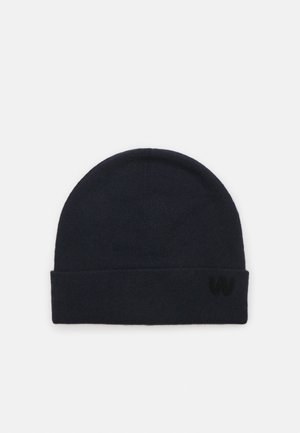 Strikket lue i mørk marineblå med en myk tekstur. Har en brettet mansjett og en liten brodert logo på siden.