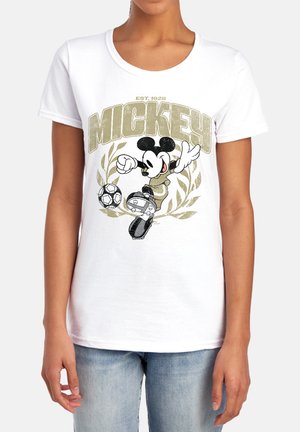 Person wearing white t-shirt with Mickey Mouse kicking a soccer ball and gold laurel wreath design.