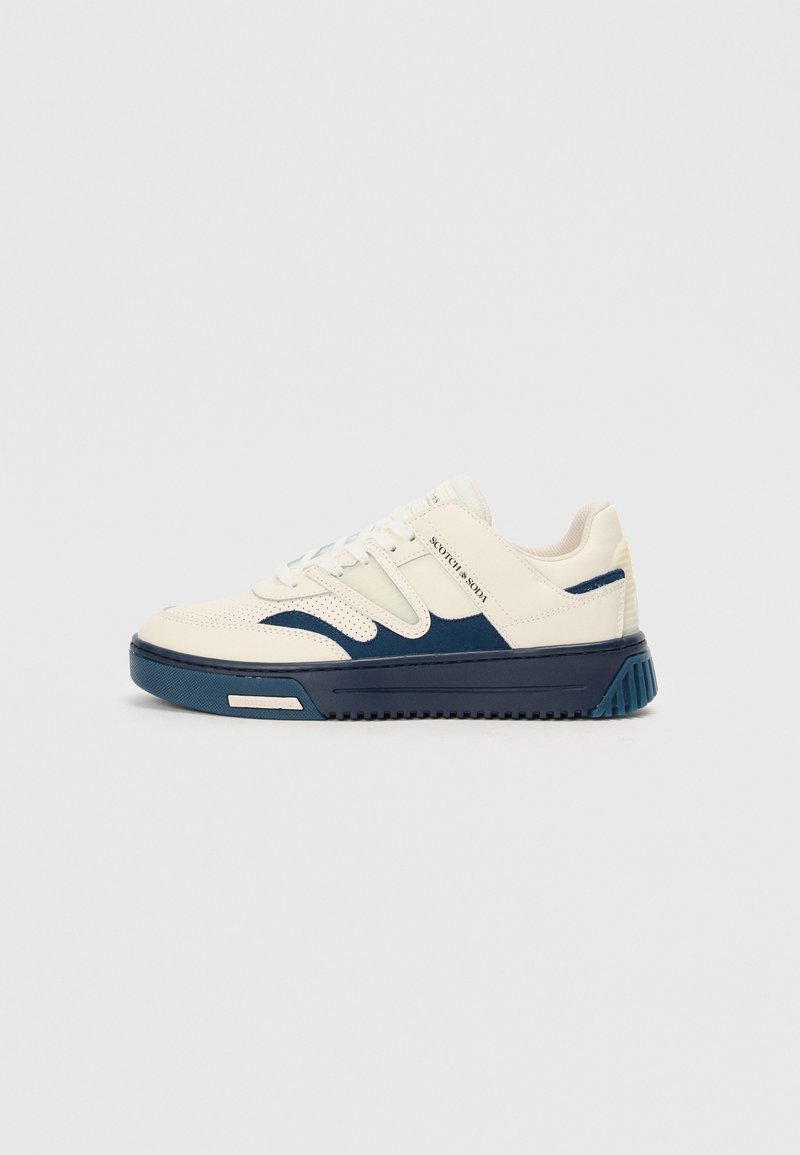 Baskets avec une tige crème, des accents bleu marine et une semelle texturée. Elles présentent un bout arrondi, un système de laçage et des détails de logo sur le côté.