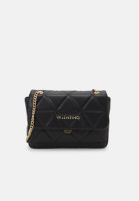 Schwarze gesteppte Leder-Umhängetasche mit einer goldenen Kettenriemen und Logodetail. Sie hat eine rechteckige Form und einen magnetischen Klappenverschluss.