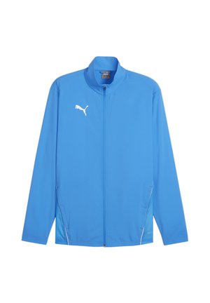 Blauwe sportjack van lichtgewicht stof. Voorzien van een ritssluiting aan de voorkant, een staande kraag en witte accenten met een logo op de linkerkant van de borst.