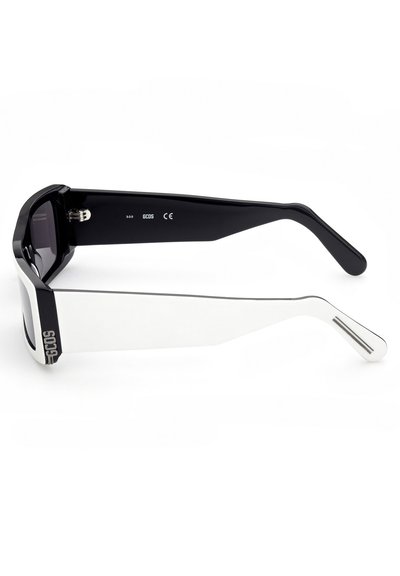 Occhiali da sole con una montatura nera ottagonale, dettagli bianchi, lenti scure e un design elegante. Presentano un dettaglio del marchio sul lato.