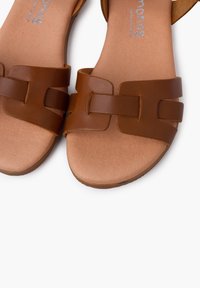 Pruunid nahast sandaalid laia rihmaga disainiga, millel on ees punutud detail. Pehme sisetald ja helepruun välistald.