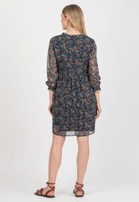 Kwiatowa sukienka w ciemnej granatowej kolorystyce, z wcięciem w talii, długimi przezroczystymi rękawami i długością do kolan. Ozdobiona wielobarwnymi wzorami kwiatowymi.
