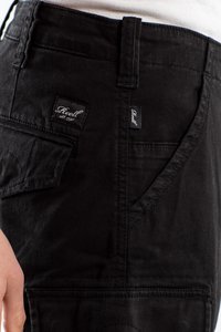 Pantalones cargo de mezclilla negra con múltiples bolsillos, etiquetas de marca en la cintura y en el bolsillo delantero, tejido texturizado y detalles de costura.