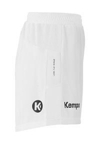 Witte sportieve shorts met elastische tailleband, mesh panelen aan de zijkanten, en bedrukt merkglogo "Kempa" en het kenmerk "2 face dry tech."