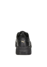 Black athletic shoe with a smooth leather upper, textured accents, and a gold logo. Features a sturdy rubber sole and padded collar design.
