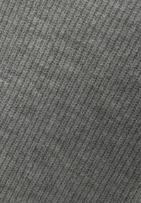Grijze gebreide stof met een textuurpatroon waarin diagonale ribbels zijn verwerkt. Het materiaal lijkt zacht en dicht, waardoor het een gezellige uitstraling heeft.