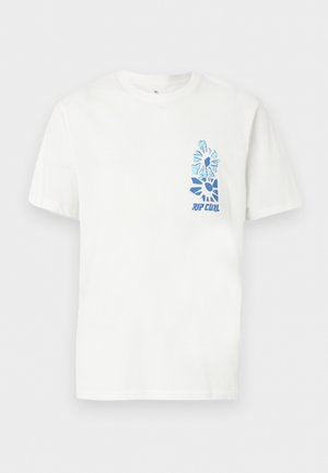 Homme portant un t-shirt blanc avec quatre impressions abstraites de fleurs bleues dans le dos, associé à un short en jean gris clair.
