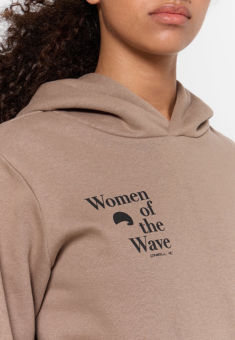 Felpa in cotone marrone con una grafica frontale che recita "Donne della Onda" in nero. Presenta un cappuccio con coulisse e una consistenza morbida.