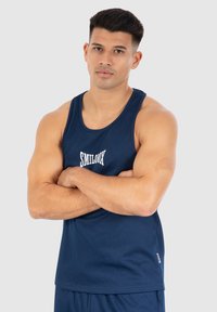 Navyblauw tanktop met ribbelstructuur, voorzien van een witte logo "SMILOOK" gecentreerd op de borst. Regular fit met brede armsgaten.