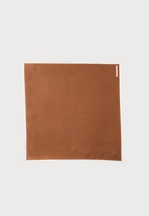 Carré de tissu marron avec une petite étiquette blanche en haut à droite, présenté à plat sur un fond clair.
