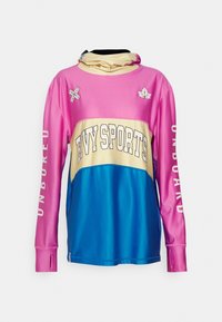 T-shirt de sport à manches longues avec une partie supérieure rose, une partie médiane beige et une partie inférieure bleue, arborant le texte "EVY SPORTS" et des trous pour les pouces sur les poignets.