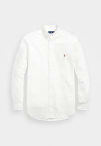 Camicia bianca con bottoni realizzata in cotone, con maniche lunghe e orlo arrotondato. Presenta un piccolo logo del polo ricamato sul petto.