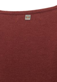 Maglione lavorato a maglia color marsala con texture a coste. Presenta un piccolo cartellino metallico con il nome del brand cucito nel colletto.