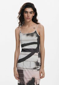 Abito in satin con scollatura a slip, caratterizzato da motivi astratti in nero e rosa, spalline sottili e una silhouette aderente. Texture liscia con un design minimale.