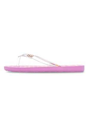 Lila flip-flop med en texturerad fotbädd, transparenta remmar och en liten metallisk logotypdetalj. Platt sula med en dämpad bas.