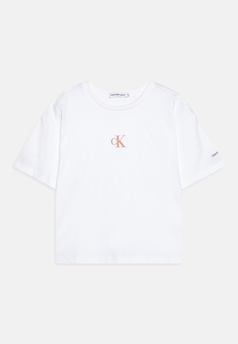 Balta medvilnė T-marškiniai su apvalia iškirpte ir trumpomis rankovėmis. Priekyje yra mažas šviesiai rudas "cK" logotipas ir prekės ženklas ant rankovės.