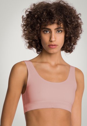 Lichtroze geribbelde crop top bralette met brede banden en een naadloos ontwerp, uitgerust met een zachte textuur en een minimalistische constructie.