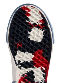 Bílá podrážka tenisek s texturovaným vzorem včelího plástu. Barvy zahrnují námořnickou modrou, červenou a bílou s abstraktními designy.