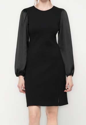 Czarna sukienka do kolan z dopasowanym gorsetem, bufkowymi satynowymi długimi rękawami marszczonymi na nadgarstkach oraz małym rozcięciem po prawej stronie.