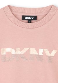 Roze sweatshirt met geribbelde halslijn en het "DKNY"-logo in metallic afwerking en studaccenten. Zachte stoftextuur, casual ontwerp.