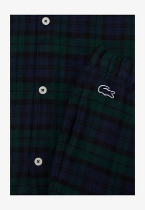 Koszula w kratę w ciemnozielonym i granatowym kolorze. Posiada białe guziki oraz małe, białe haftowane logo krokodyla na kieszeni. Miękka faktura materiału.